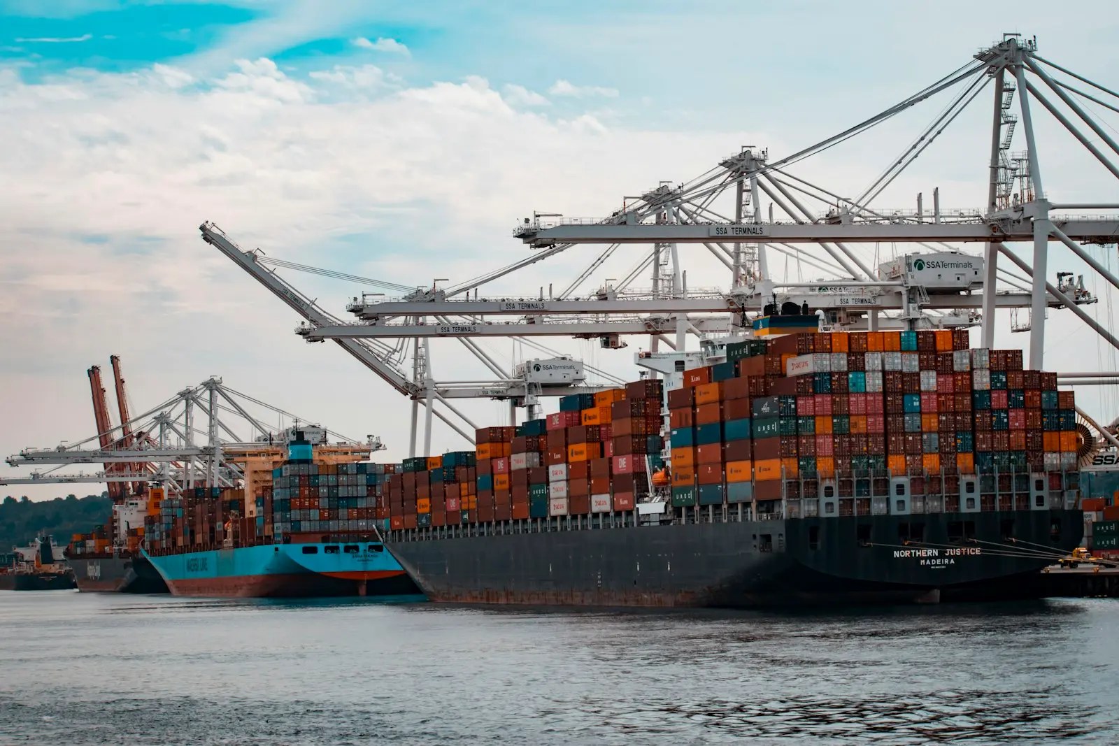 Buque portacontenedores siendo cargado con grúas en un puerto, listo para exportar mercancía desde China
