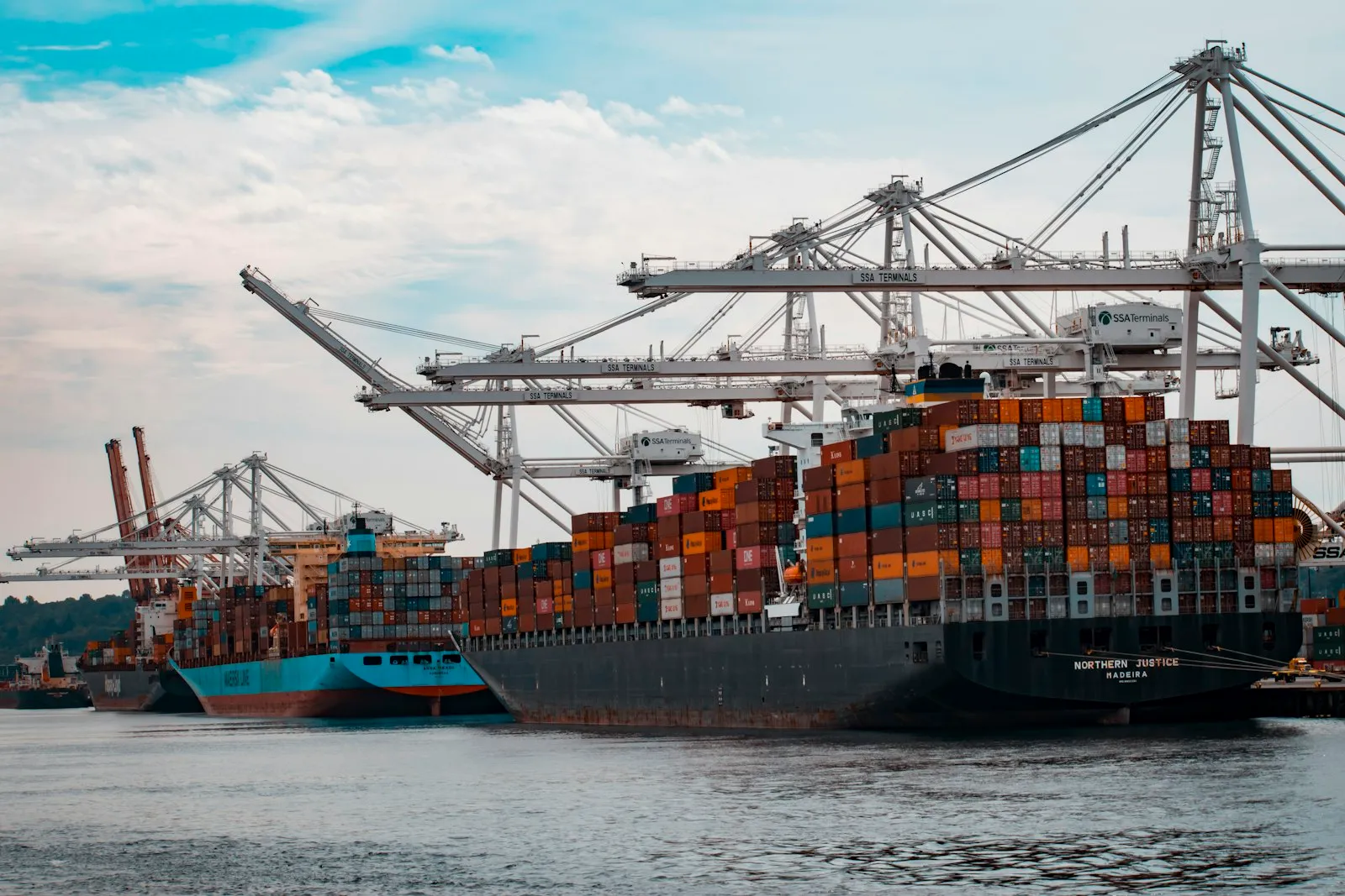 Buque portacontenedores siendo cargado con grúas en un puerto, listo para exportar mercancía desde China