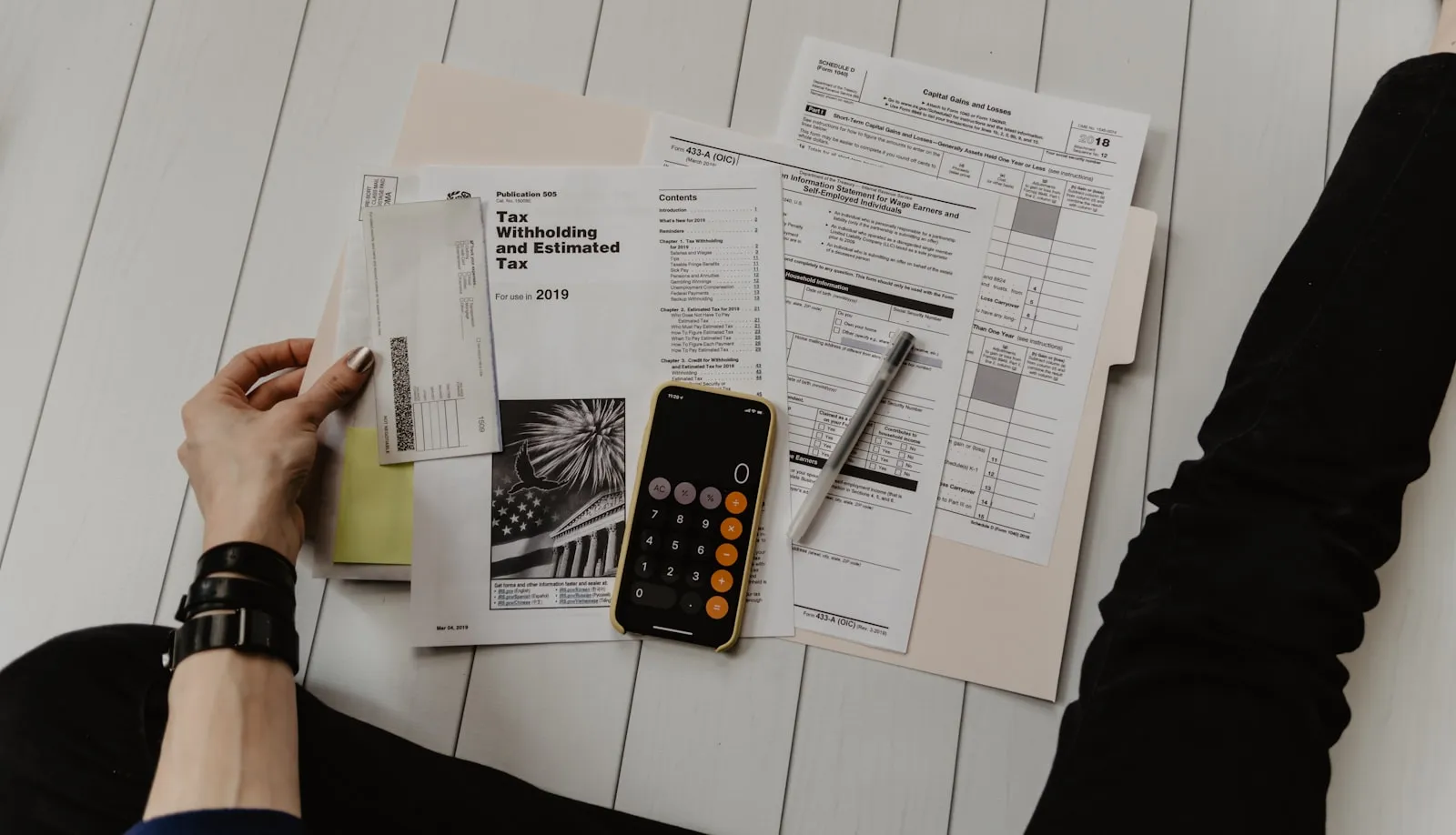Calculadora y documentos fiscales sobre una mesa, calculando los impuestos de una importación