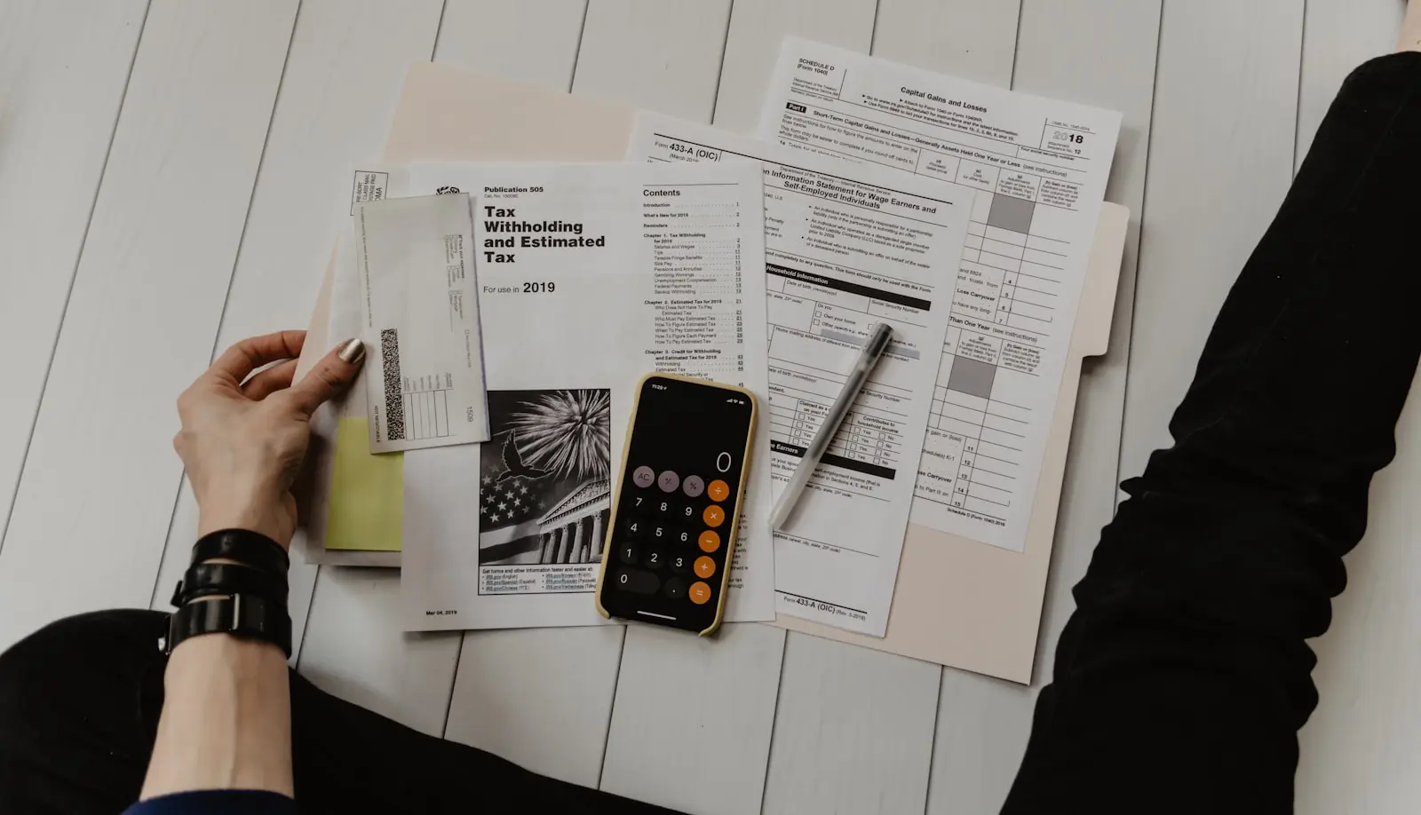 Calculadora y documentos fiscales sobre una mesa, calculando los impuestos de una importación